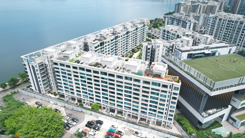 a large white building (Providence Bay) next to a body of water